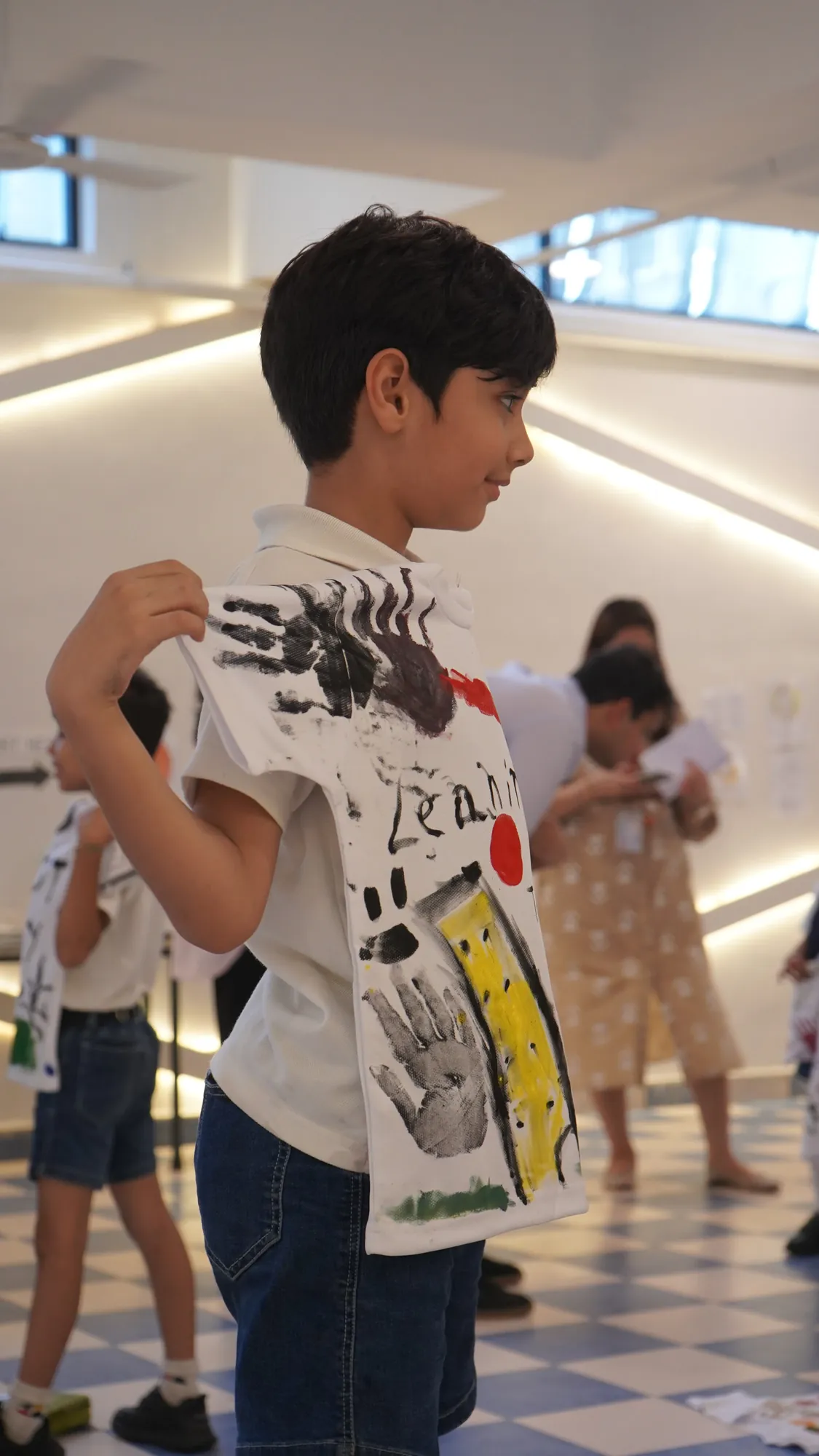 A student holding up the T-shirt he painted