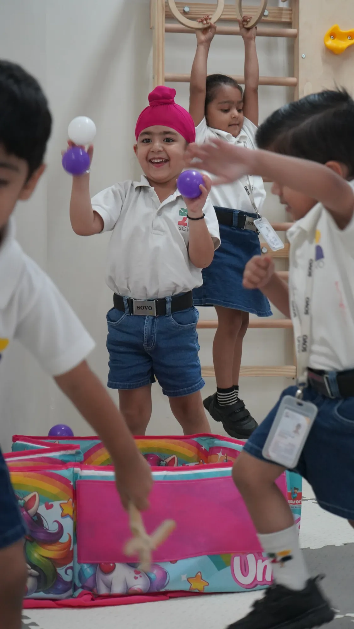 A young boy laughing as he plays with a ball