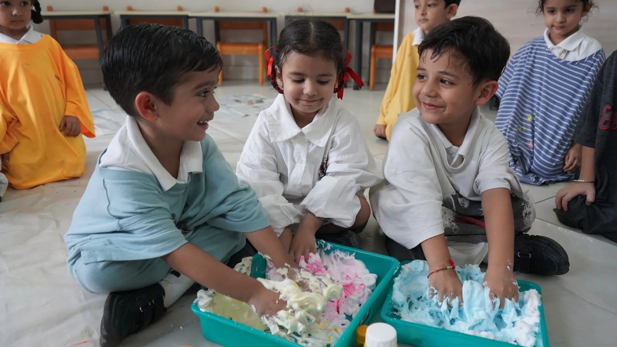 Young children exploring foam in sensory trays