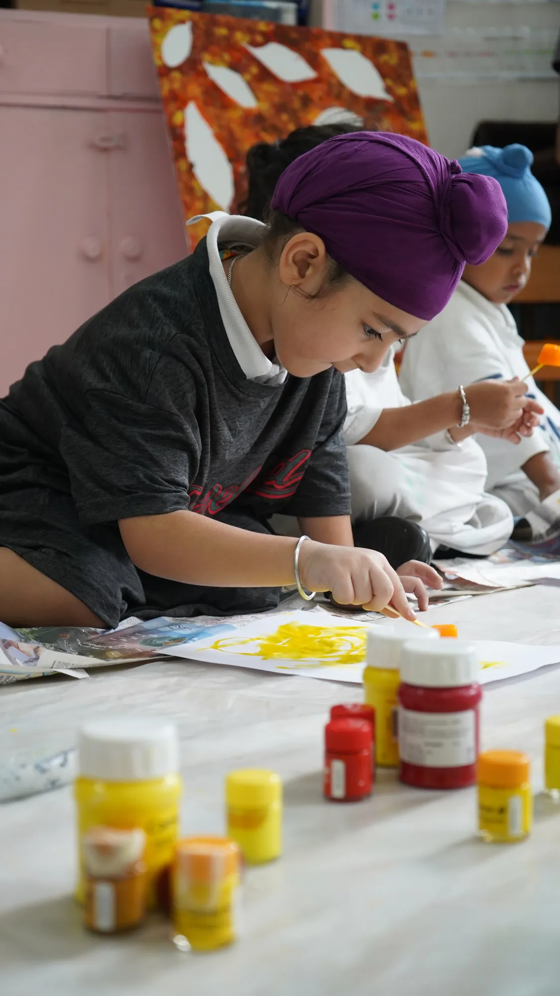 A young child concentrating on a painting