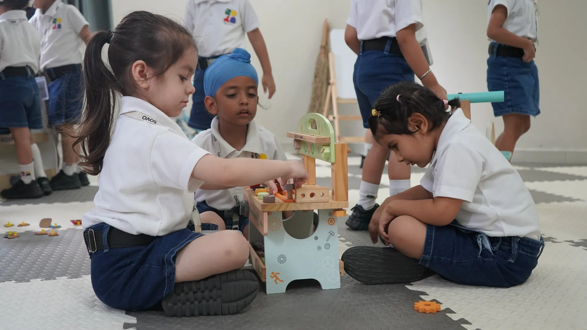 Two children working with tools at a wooden workbench