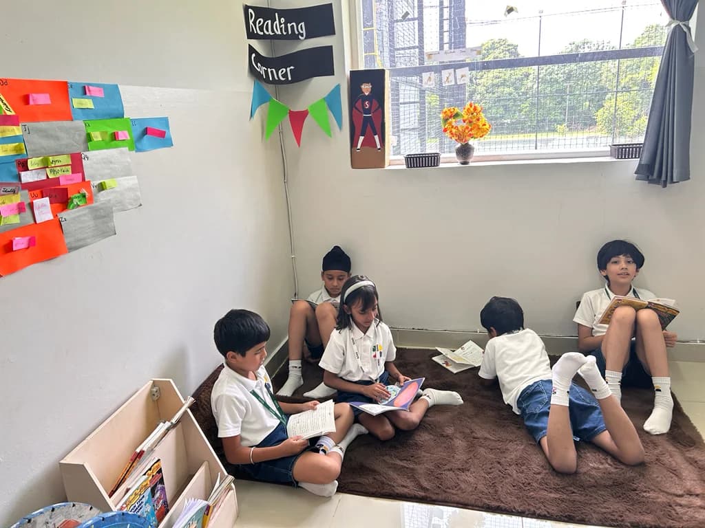 Students reading books on a rug in their classroom reading corner