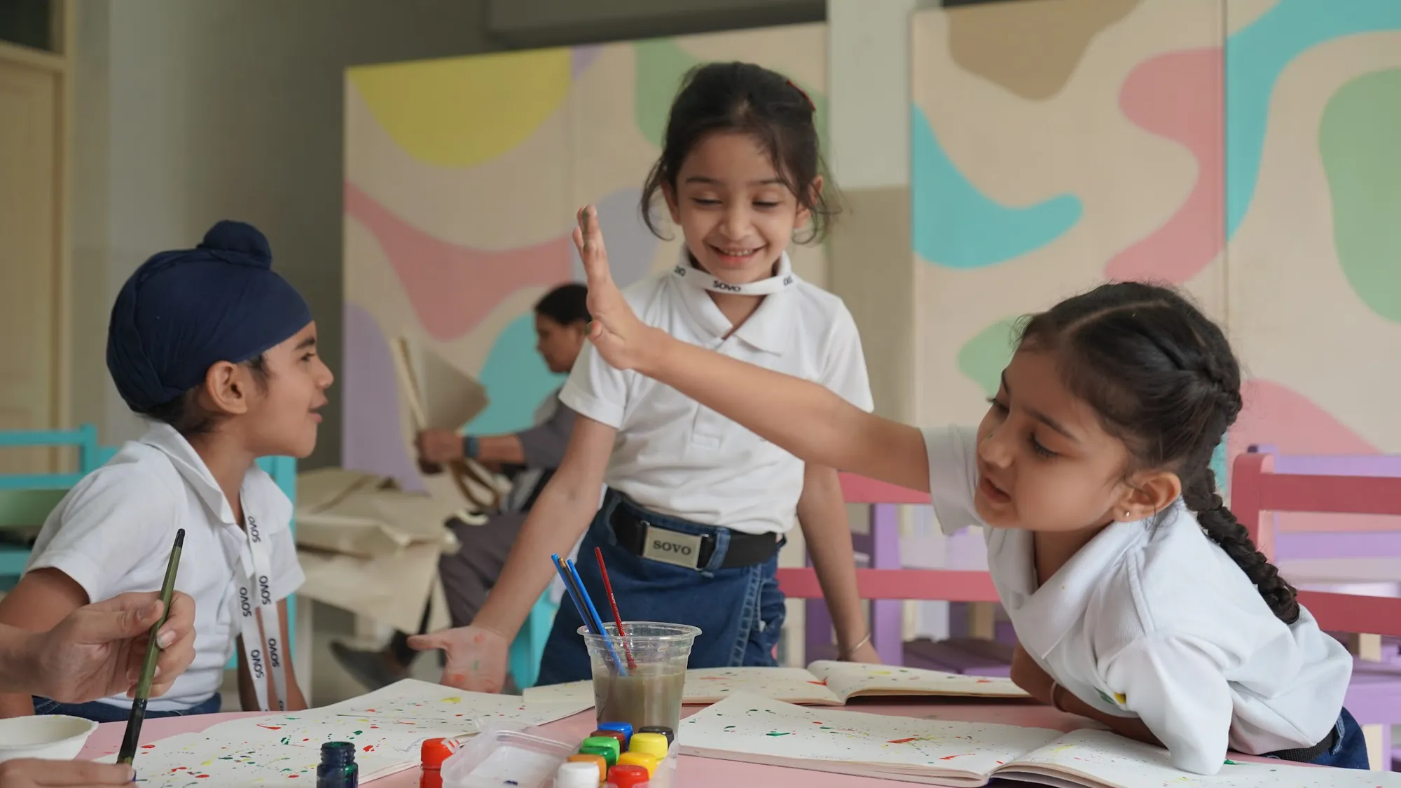 SOVO students sharing a high-five during an art lesson
